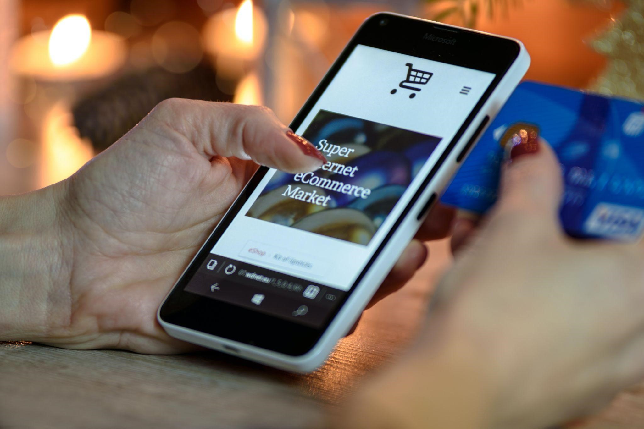 A woman holding a smartphone opened on an ecommerce market